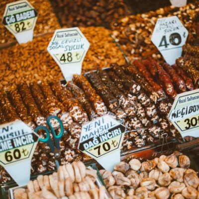 A colorful display of nuts and sweets with price tags at a Turkish market stall.