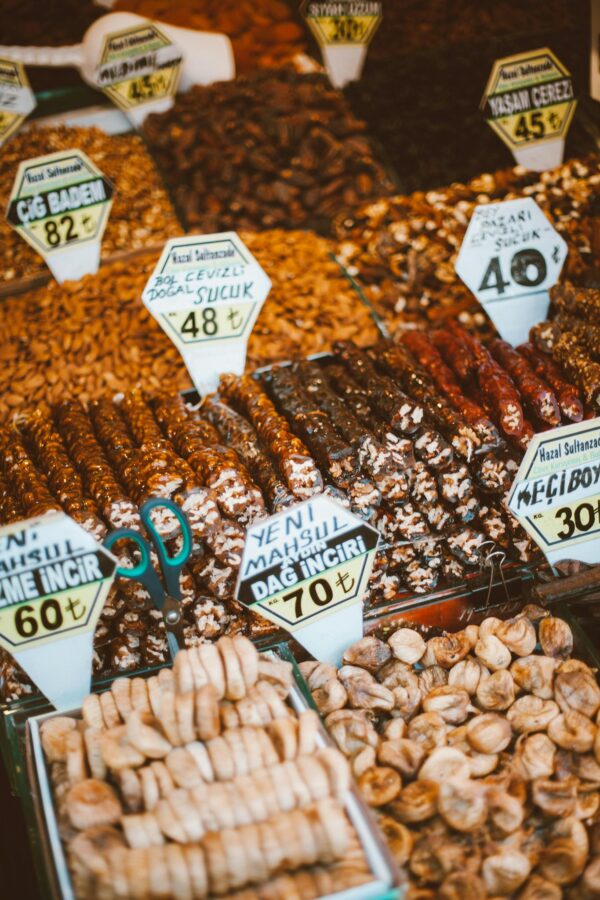 A colorful display of nuts and sweets with price tags at a Turkish market stall.