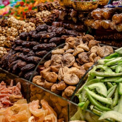 A vibrant assortment of dried fruits and nuts at a bustling market stall, showcasing variety and preservation.