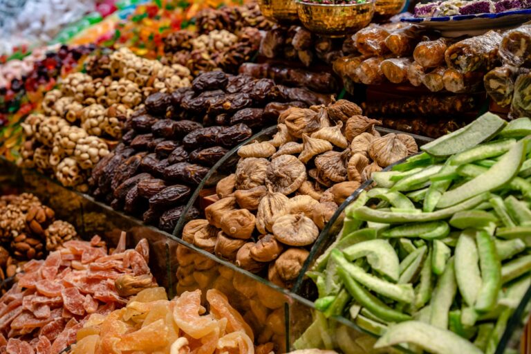 A vibrant assortment of dried fruits and nuts at a bustling market stall, showcasing variety and preservation.